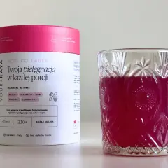 Kolagen rybi na stawy w proszku o smaku róży i maliny, obok szklanki z różowym napojem.
