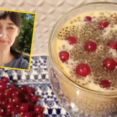 Kobieta uśmiecha się obok deseru z nasionami chia i owocami. Na talerzyku obok leżą czerwone porzeczki.