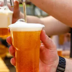 Nalewanie piwa bezalkoholowego do kubka. Zastanawiasz się, ile kalorii ma piwo bezalkoholowe? To świetny wybór na orzeźwienie!