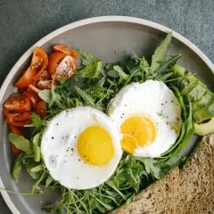 Śniadanie idealne na dieta 2000 kcal: jajka sadzone, pomidorki, awokado i pełnoziarnisty tost.