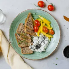 Szybkie posiłki wysokobiałkowe: twarożek z czarnuszką, pieczywo, pomidorki i papryka. Idealne na lekki lunch.