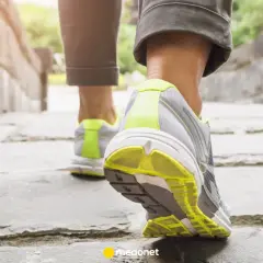 Zbliżenie na nogi w butach sportowych idące po kamiennej ścieżce.
