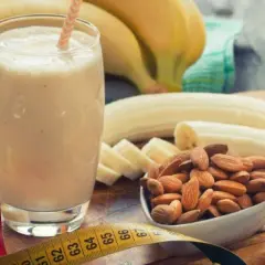 Pyszny shake proteinowy na odchudzanie z bananem i migdałami. Miarka krawiecka sugeruje cel sylwetki.