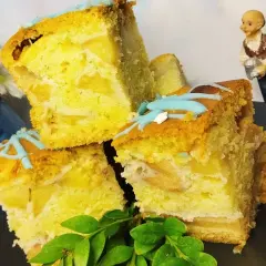 Wilgotne ciasto z białek z jabłkami, udekorowane błękitnym lukrem. Pyszny deser na talerzu.