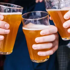 Trzy osoby wznoszą toasty piwem bezalkoholowym. Czy piwo bezalkoholowe jest zdrowe? To pytanie zadaje sobie wielu.