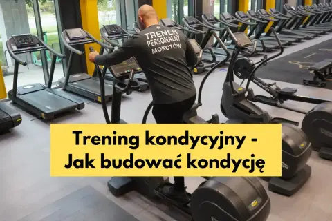 Mężczyzna w koszulce "Trener Personalny Mokotów" ćwiczy na orbitreku. W tle bieżnie i inne maszyny cardio, idealne do treningu kondycyjnego.