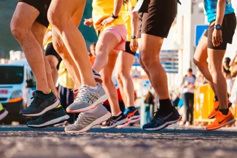 Uczestnicy biegu, nogi w ruchu, buty sportowe. To świetny przykład treningu funkcjonalnego w akcji.