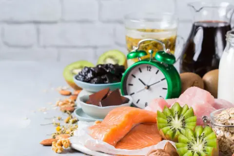 Zegar i produkty bogate w tryptofan: łosoś, kiwi, orzechy, mleko, owies, śliwki. Zastanawiasz się, po jakim czasie działa tryptofan?
