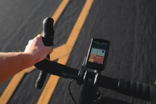 Dłoń na kierownicy roweru, na ekranie nawigacja z trasą i danymi. Ta aplikacja na rower ułatwia jazdę.