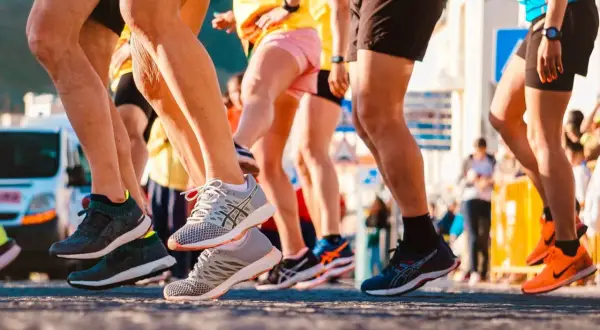 Uczestnicy biegu, nogi w ruchu, buty sportowe. To świetny przykład treningu funkcjonalnego w akcji.
