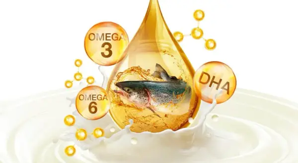 Ryba w kropli oleju, otoczona bańkami z napisami Omega 3, Omega 6 i DHA, symbolizująca zdrowe tłuszcze.