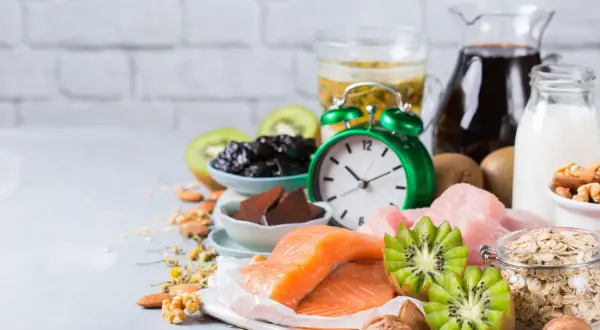 Zegar i produkty bogate w tryptofan: łosoś, kiwi, orzechy, mleko, owies, śliwki. Zastanawiasz się, po jakim czasie działa tryptofan?