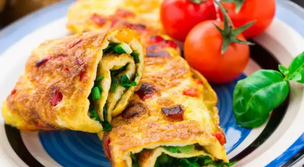 Roladki z omletu z zielonymi warzywami i pomidorkami koktajlowymi. Pyszne śniadanie bez chleba.