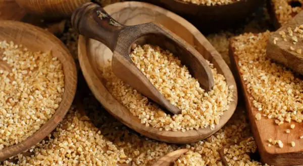 Kasza bulgur w drewnianych naczyniach. Niska kasza bulgur indeks glikemiczny sprawia, że jest zdrowym wyborem.