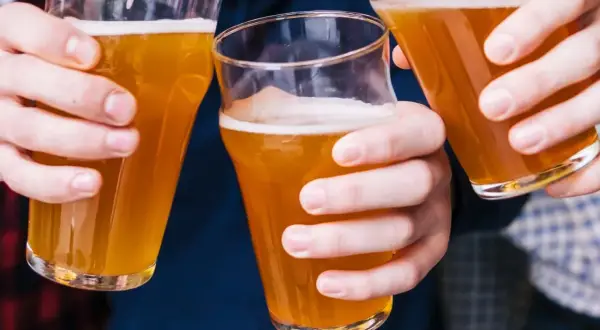 Trzy osoby wznoszą toasty piwem bezalkoholowym. Czy piwo bezalkoholowe jest zdrowe? To pytanie zadaje sobie wielu.