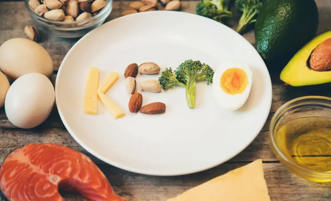 Czy dieta keto jest zdrowa? Na talerzu litery KETO z sera, orzechów, brokuła i jajka. Wokół łosoś, awokado, oliwa.