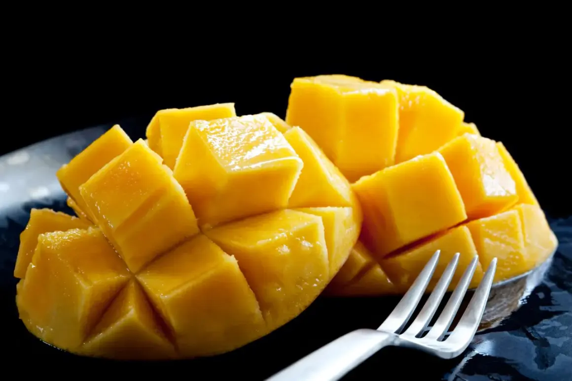 Soczyste, pokrojone w kostkę mango, jak na zdjęciu, budzi pozytywne african mango opinie. Widoczny widelec sugeruje gotowość do degustacji.