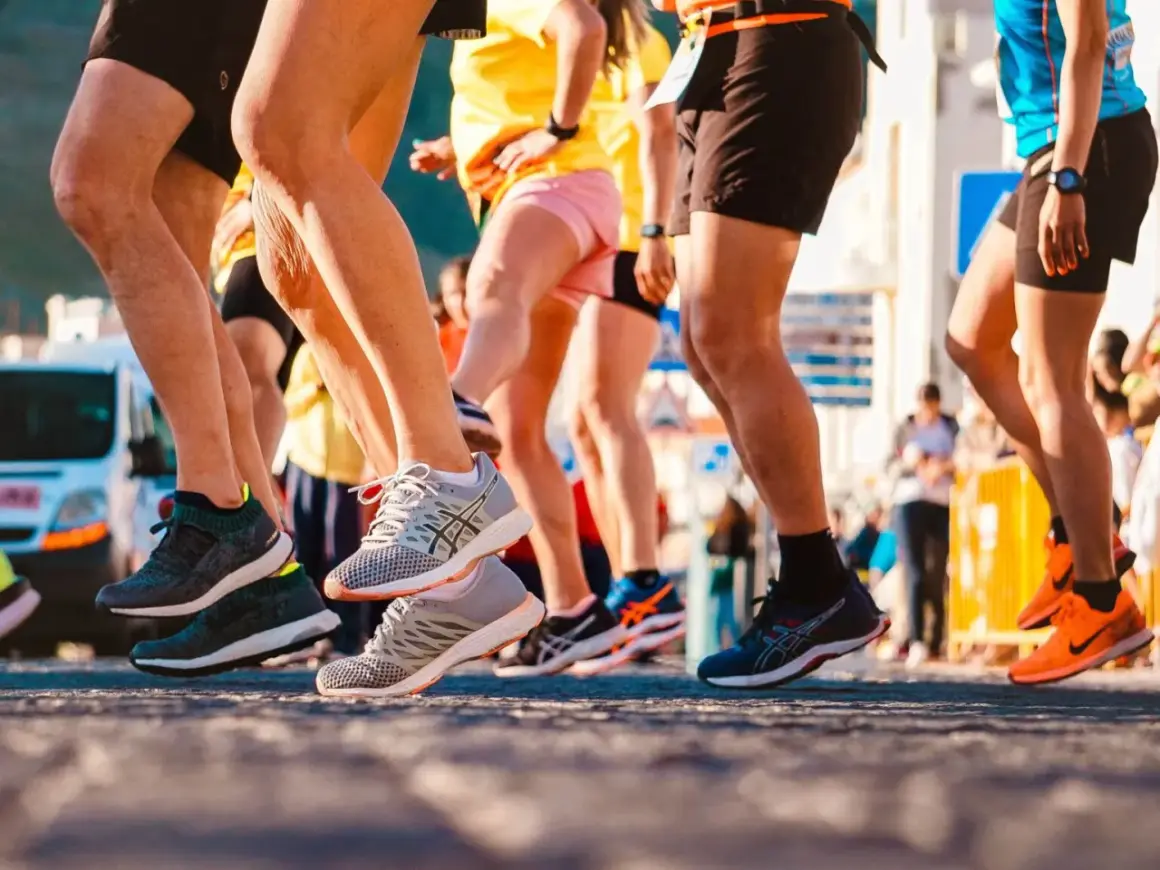 Uczestnicy biegu, nogi w ruchu, buty sportowe. To świetny przykład treningu funkcjonalnego w akcji.