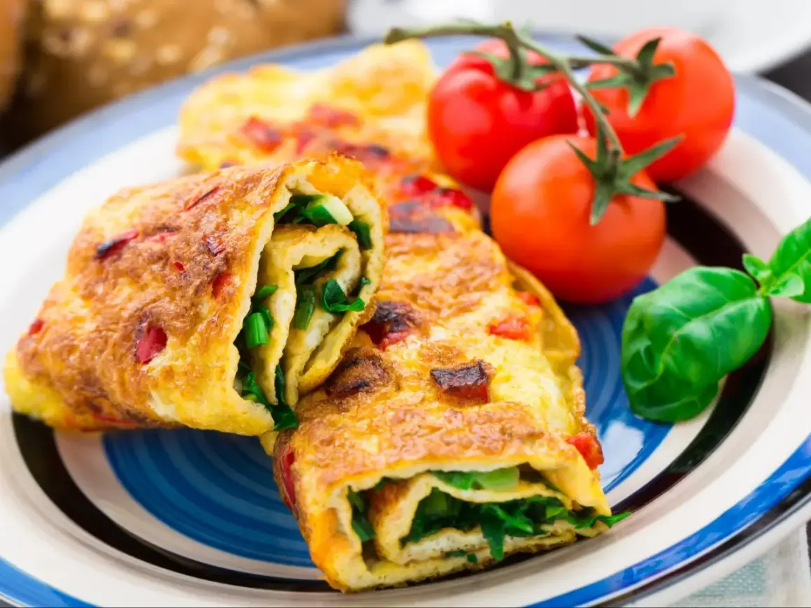 Roladki z omletu z zielonymi warzywami i pomidorkami koktajlowymi. Pyszne śniadanie bez chleba.
