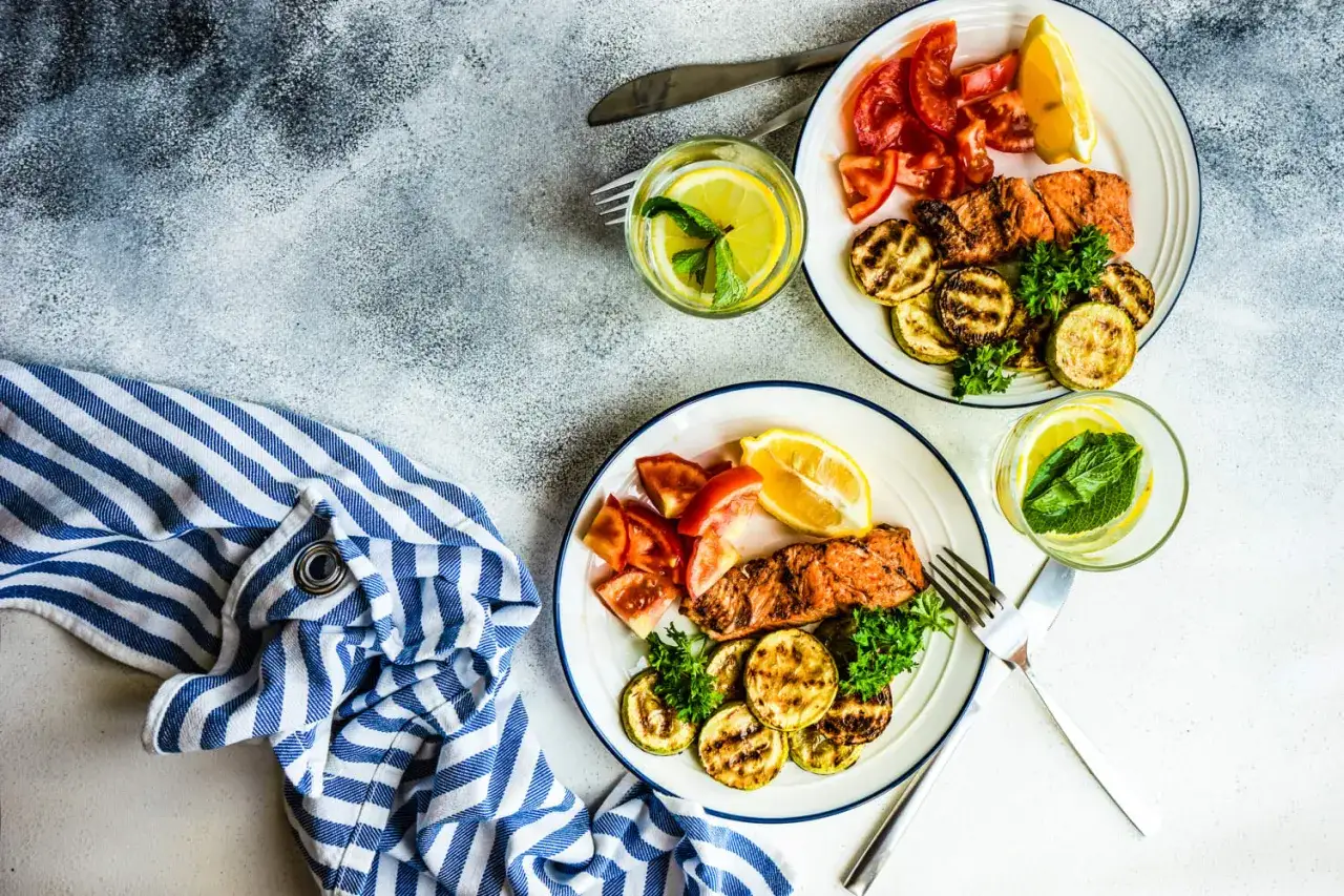 Dwa talerze z łososiem, grillowaną cukinią i pomidorami. Idealne na dietę low carb co to znaczy? Zdrowe i pyszne!