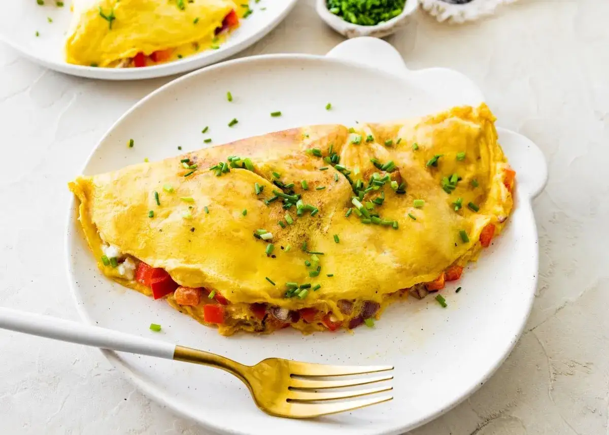 Puszysty omlet z białek z papryką i cebulą, posypany szczypiorkiem. Idealny lekki posiłek.
