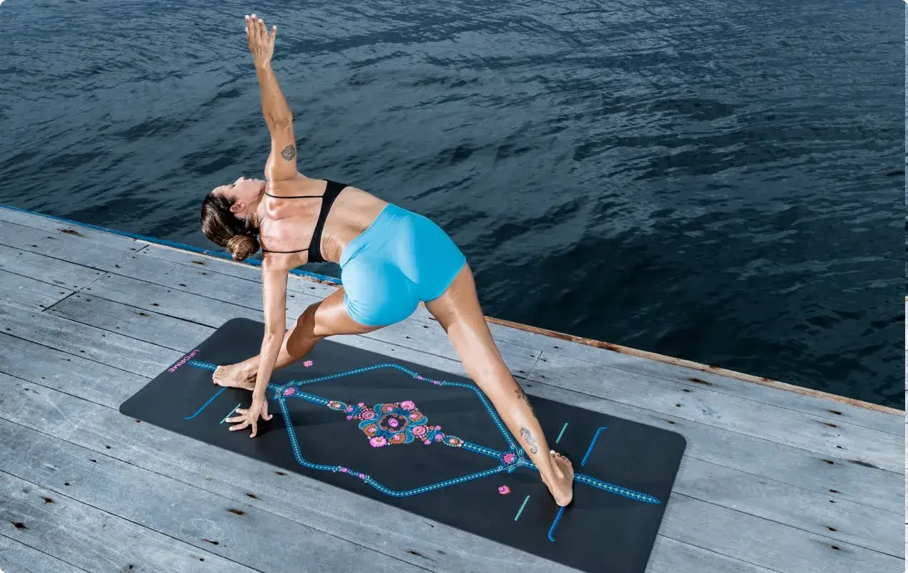 Kobieta w pozie jogi na macie nad wodą, ćwicząca świadomy oddech, jak podczas yoga nidra.