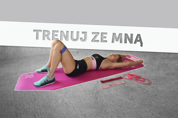 Kobieta ćwiczy na macie, używając gum oporowych. Idealny plan treningowy dla kobiet, by wzmocnić ciało.