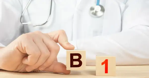 Dłoń lekarza układa kostki z literą B i cyfrą 1. Witamina B1 na co wpływa?