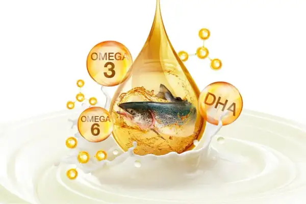 Ryba w kropli oleju, otoczona bańkami z napisami Omega 3, Omega 6 i DHA, symbolizująca zdrowe tłuszcze.